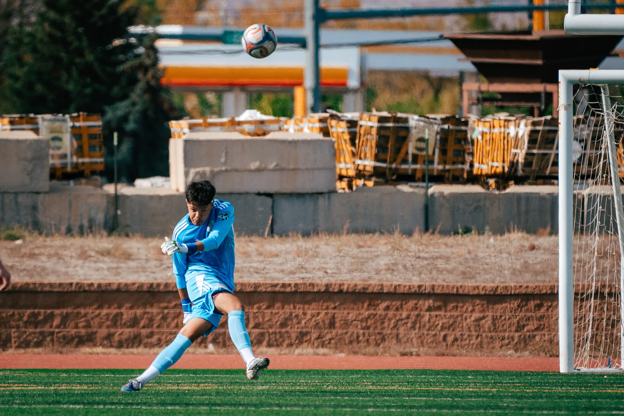 The Albion SC Colorado goalkeeper in light blue follows through on a kick as the ball sails away