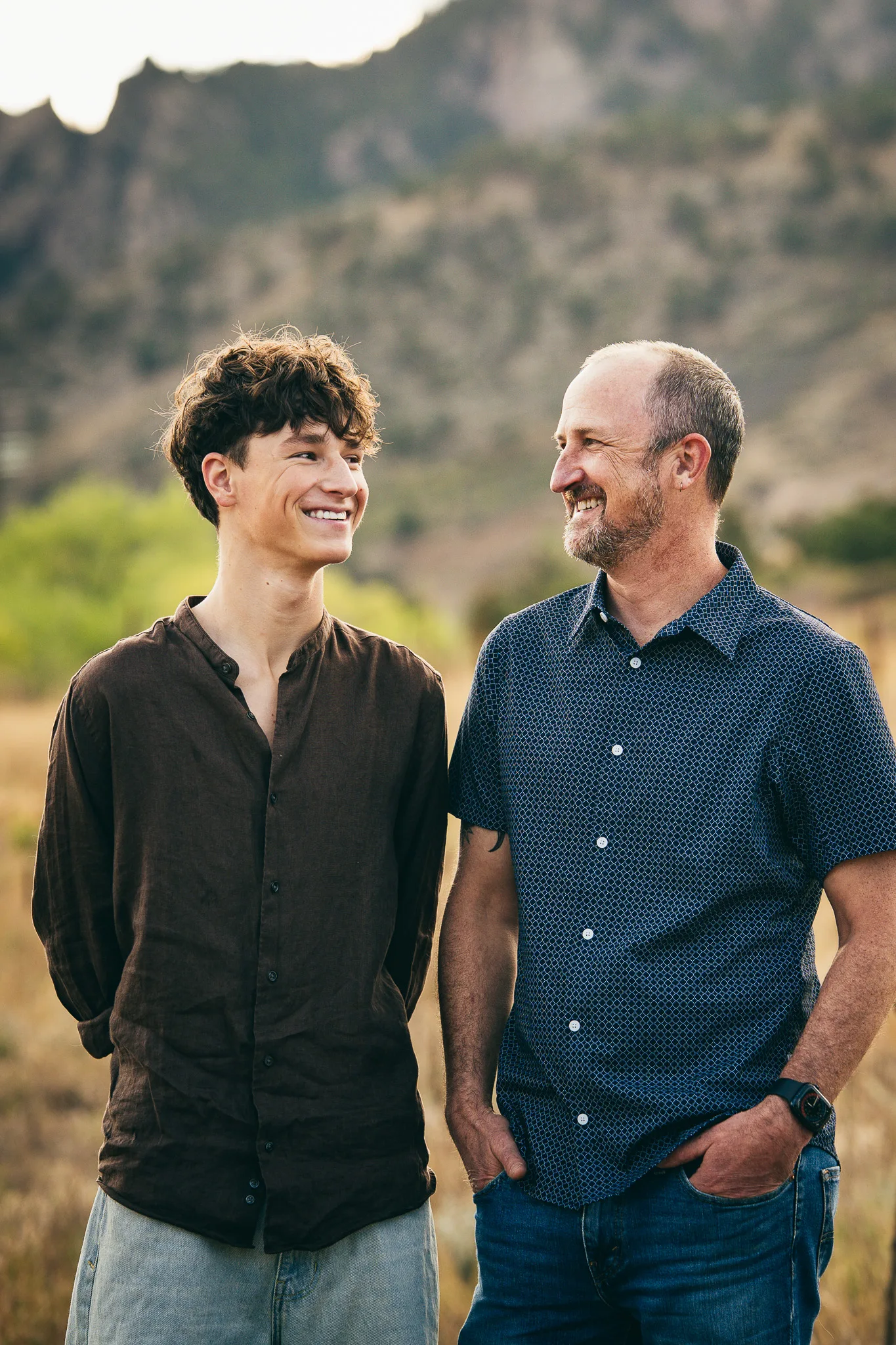 Arlo and his dad, Dusty, grin at each other side by side in the evening light.