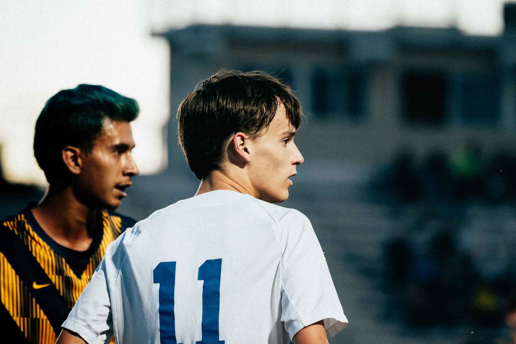 Seen from behind, Centaurus number 11 looks off to the side as a Frederick player behind him looks the same way