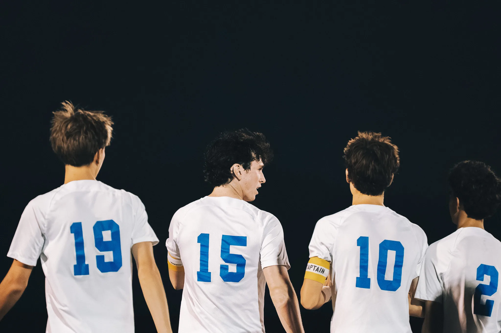 Seen from behind against the dark, Centaurus numbers 19, 15, 10 and 2 stand together, number 10 wearing a captain's armband