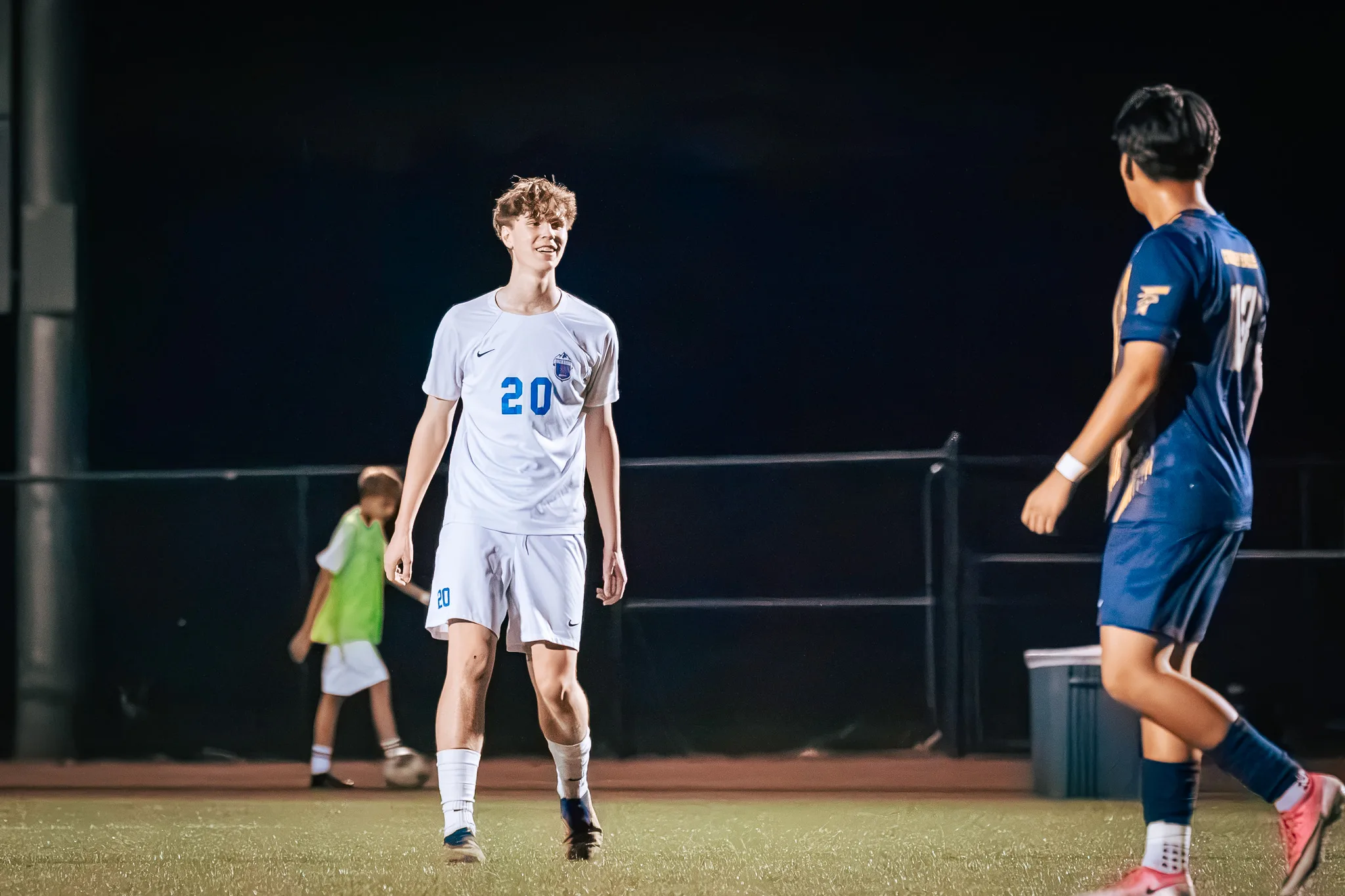 Smiling, Centaurus number 20 walks upfield as a Frederick player passes in the foreground and a player in a green vest collects a ball behind him