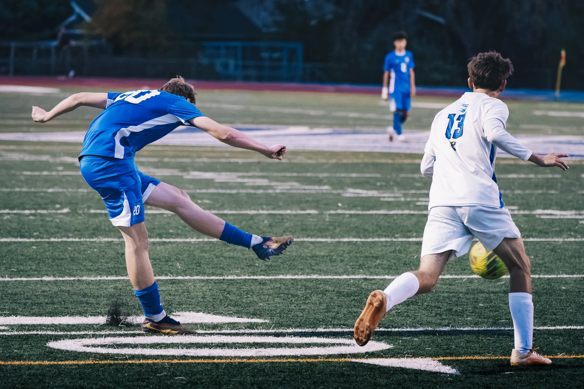 As the ball travels toward Longmont number 13, Centaurus number 20 follows through on a kick