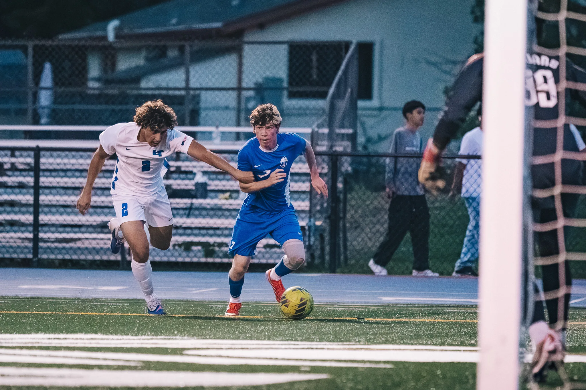 Heading for the goal, a Centaurus player dribbles with Longmont number 2 at his side and the Longmont goalkeeper at the edge of the frame
