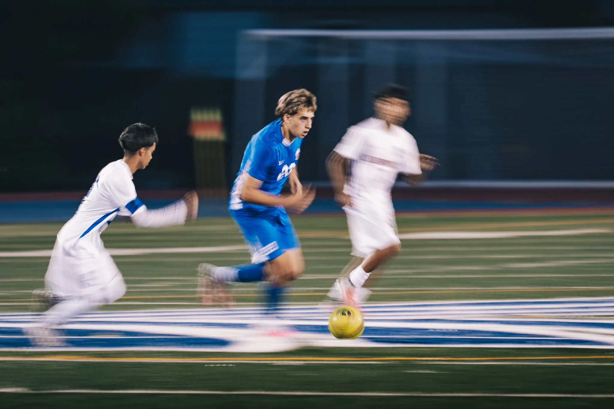 Streaked with motion, Centaurus number 20 sprints with the ball between two Longmont players