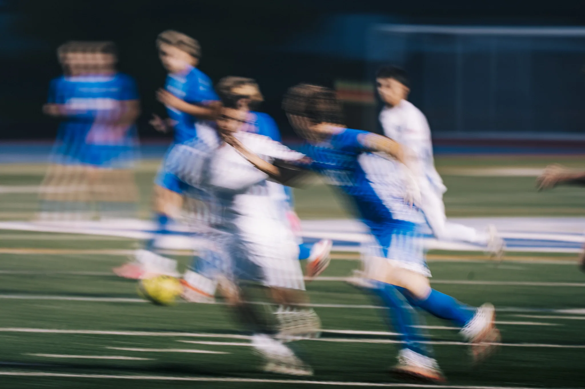 Centaurus and Longmont players streak across the field in a blur as they go for the ball