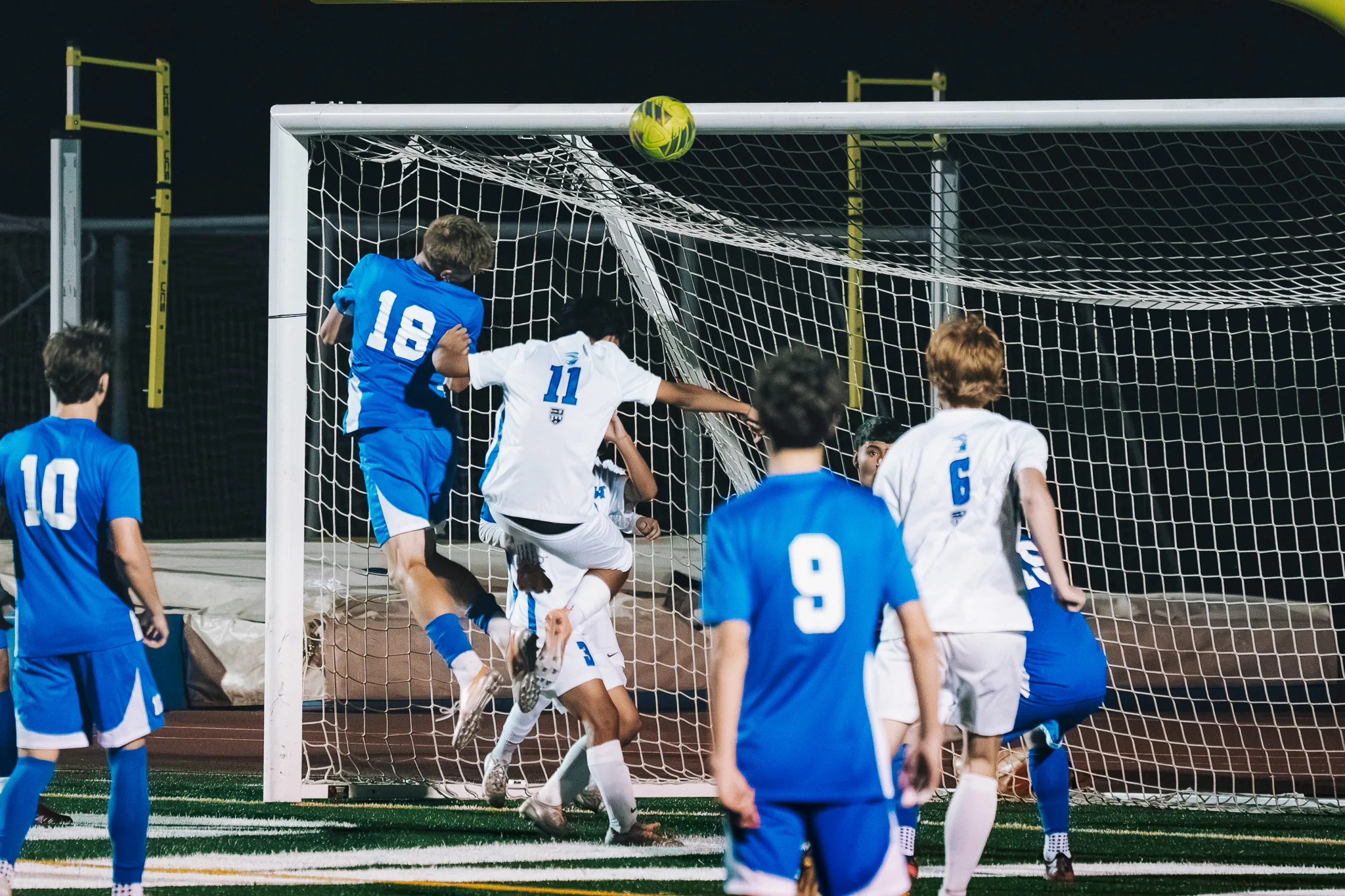 At the goal, Centaurus number 18 and Longmont number 11 leap for a high ball as Centaurus numbers 9 and 10 look on