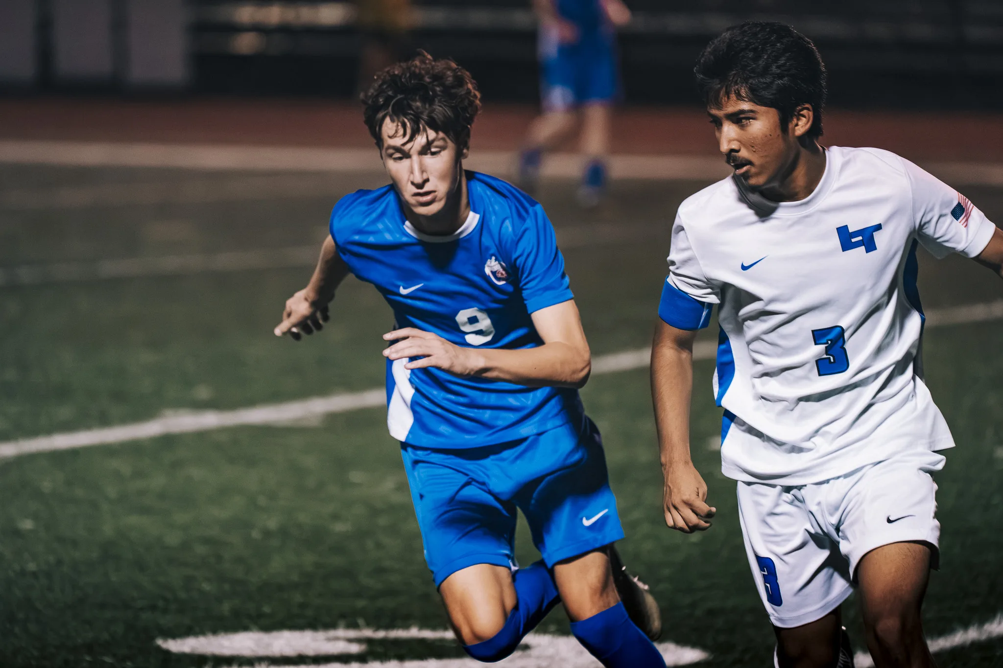 Side by side, Centaurus number 9 and Longmont number 3 sprint, both watching the play ahead