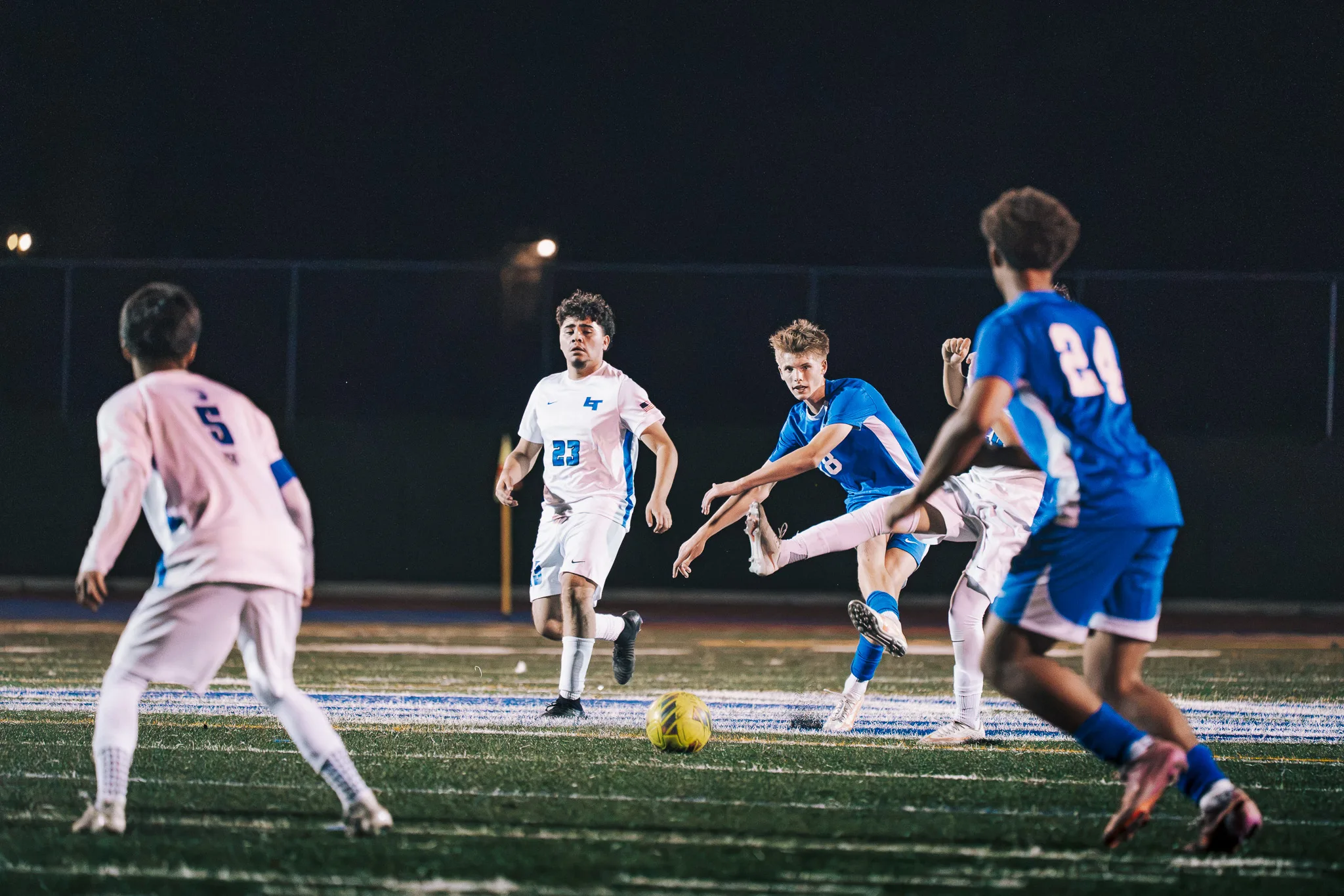Players from both teams crowd around the ball, with Longmont numbers 5 and 23 on the left and Centaurus number 24 in the foreground