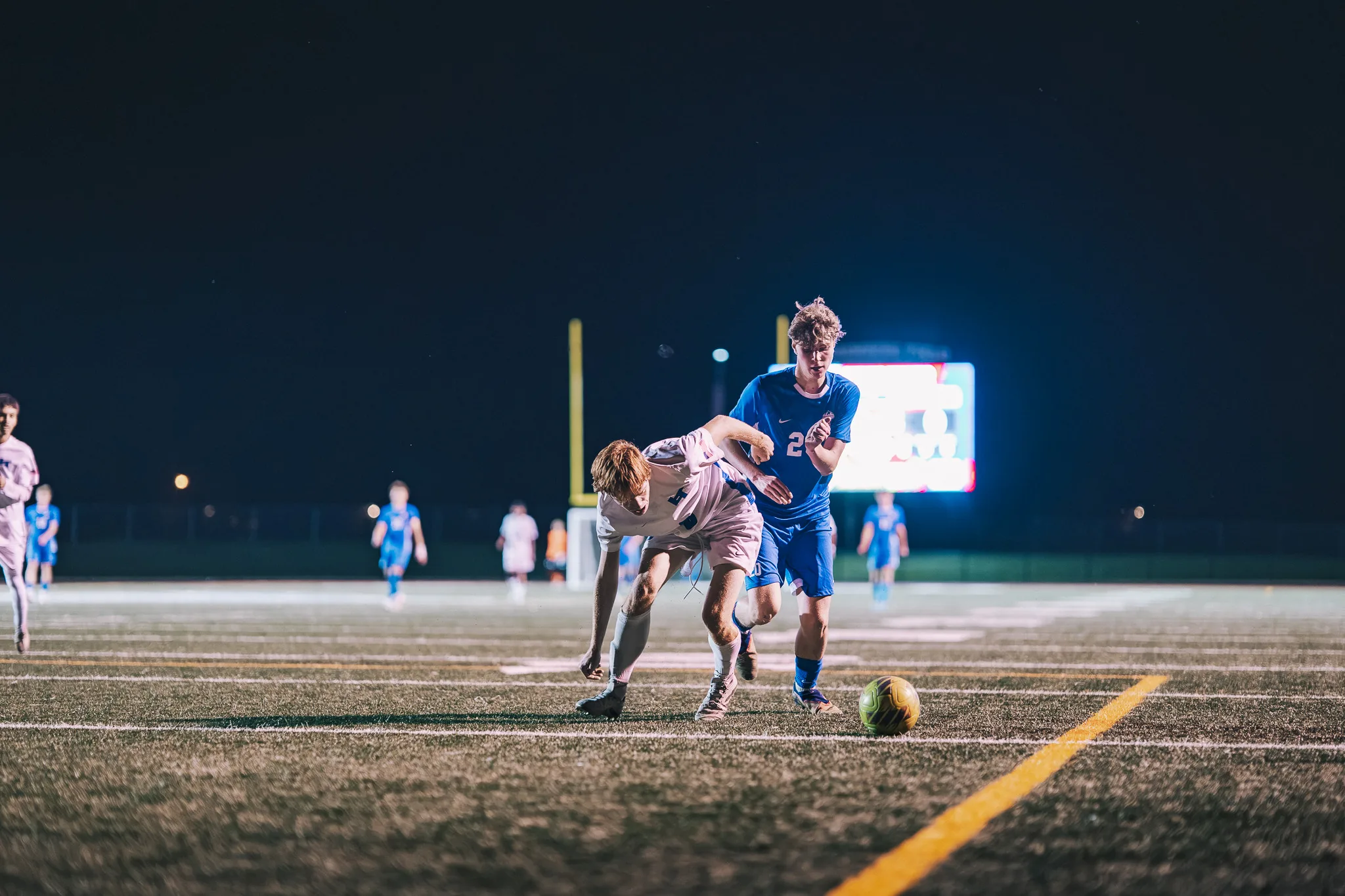 A Centaurus player and a Longmont player tangle as they both go for the ball, the Longmont player bent low