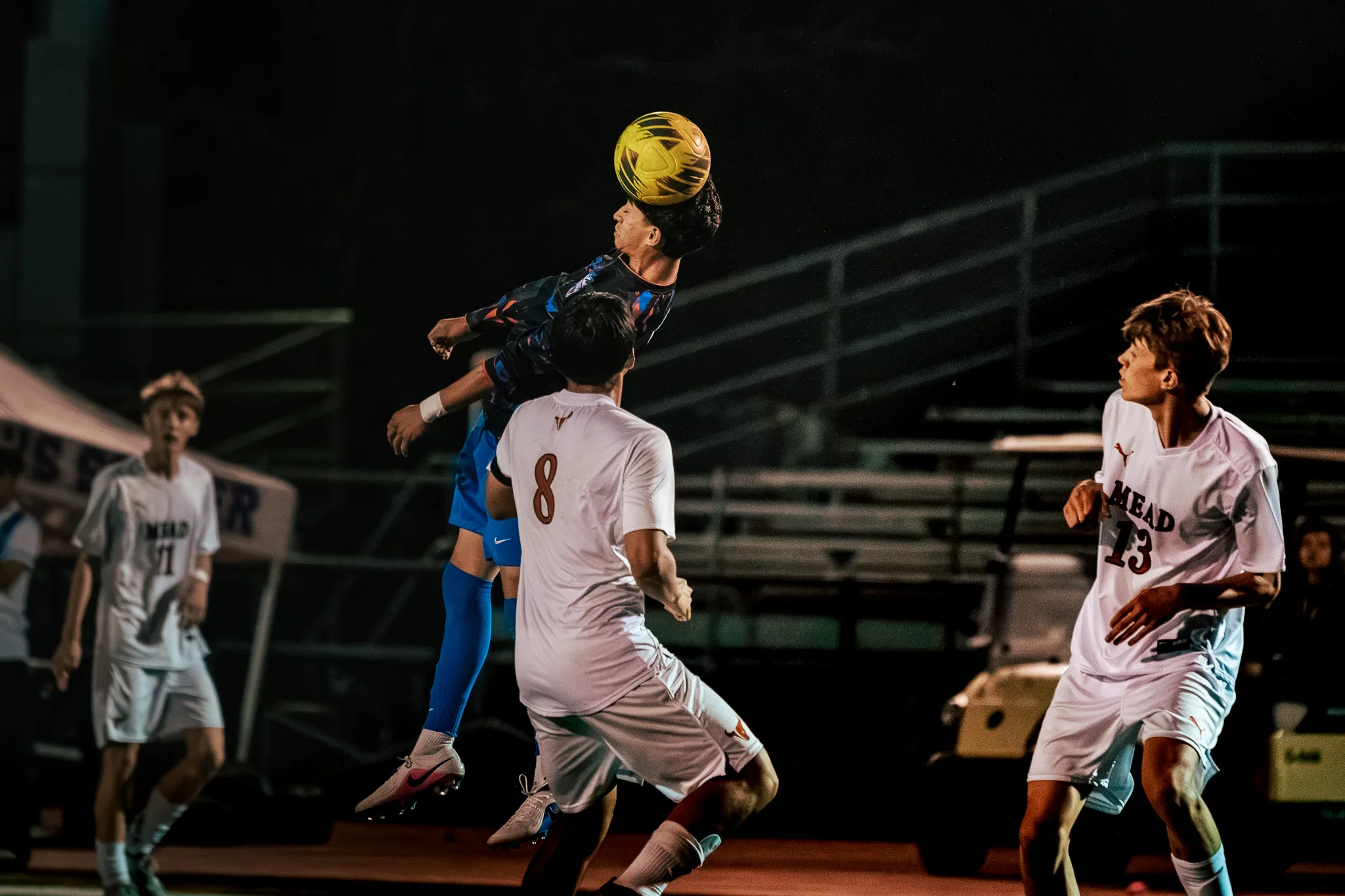 A Centaurus player rises above Mead number 8 to head the ball as Mead number 13 and another Mead player look on