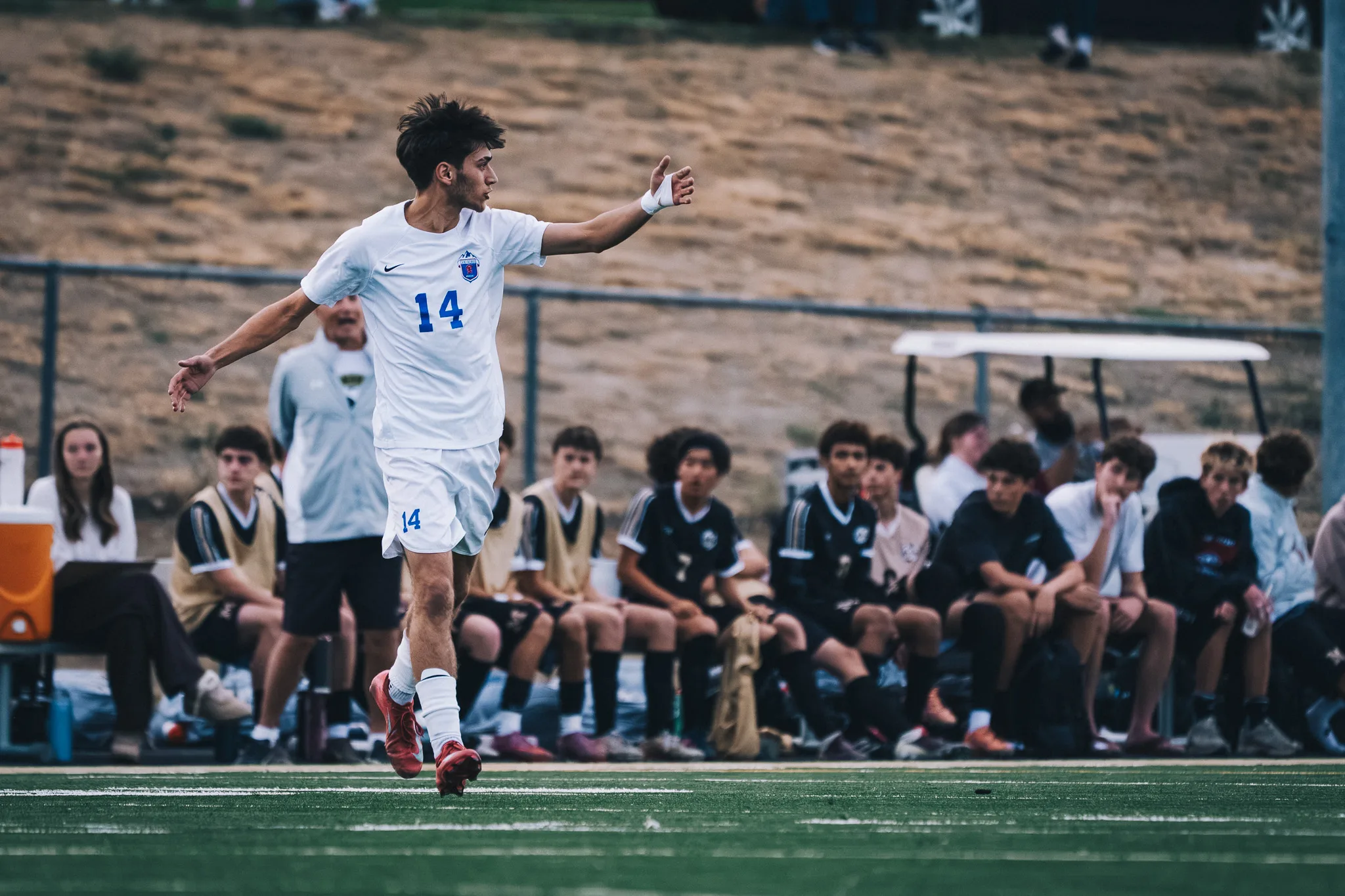 Centaurus number 14 calls for the ball along the sideline, the Monarch bench behind him