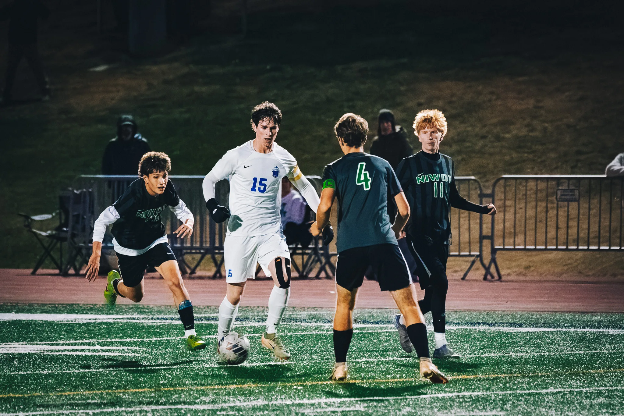 Centaurus number 15 brings the ball toward Niwot number 4 as Niwot number 11, with red hair, and another Niwot player move in
