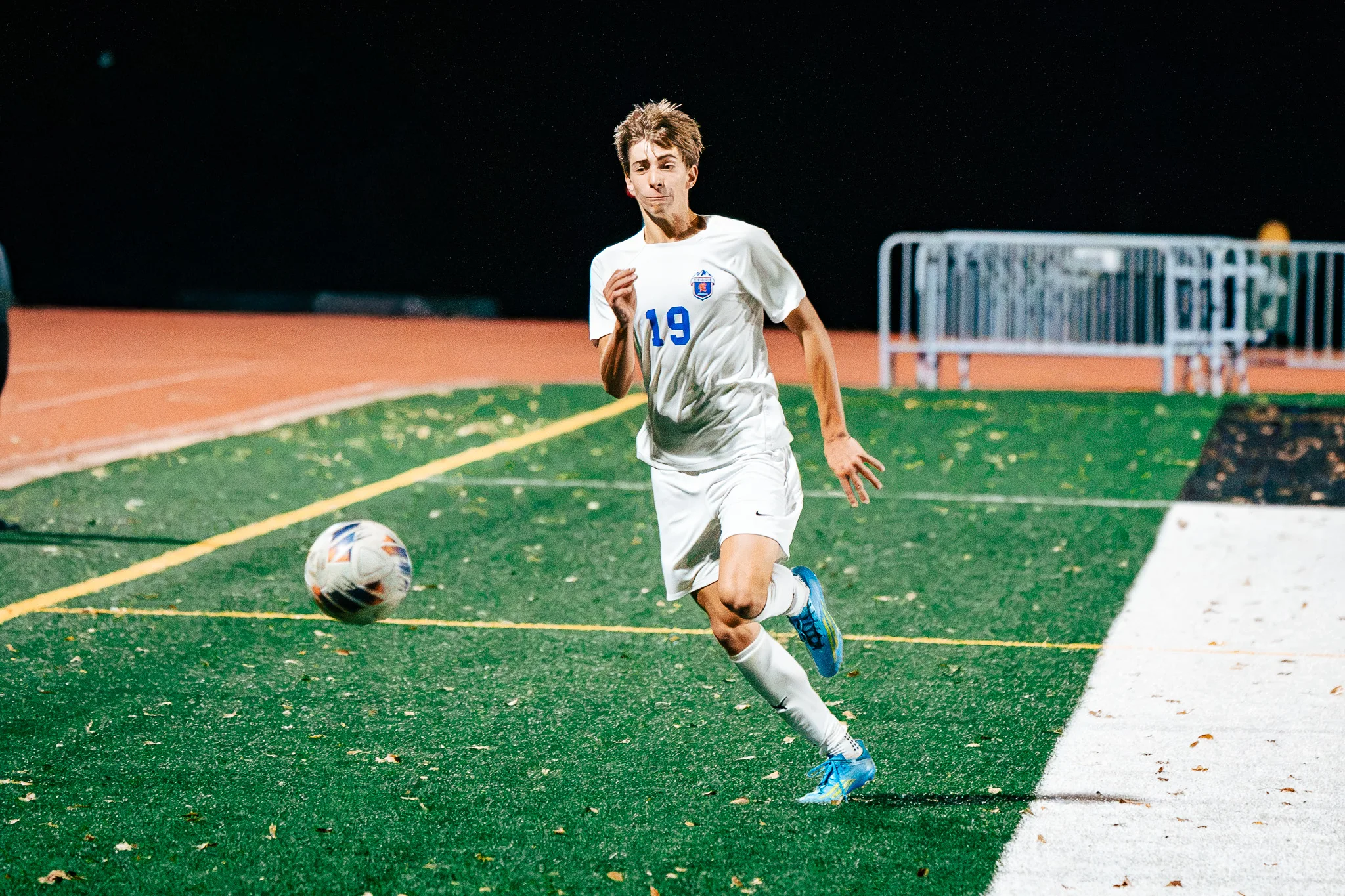 Centaurus number 19 chases the ball toward the sideline, fallen leaves on the turf