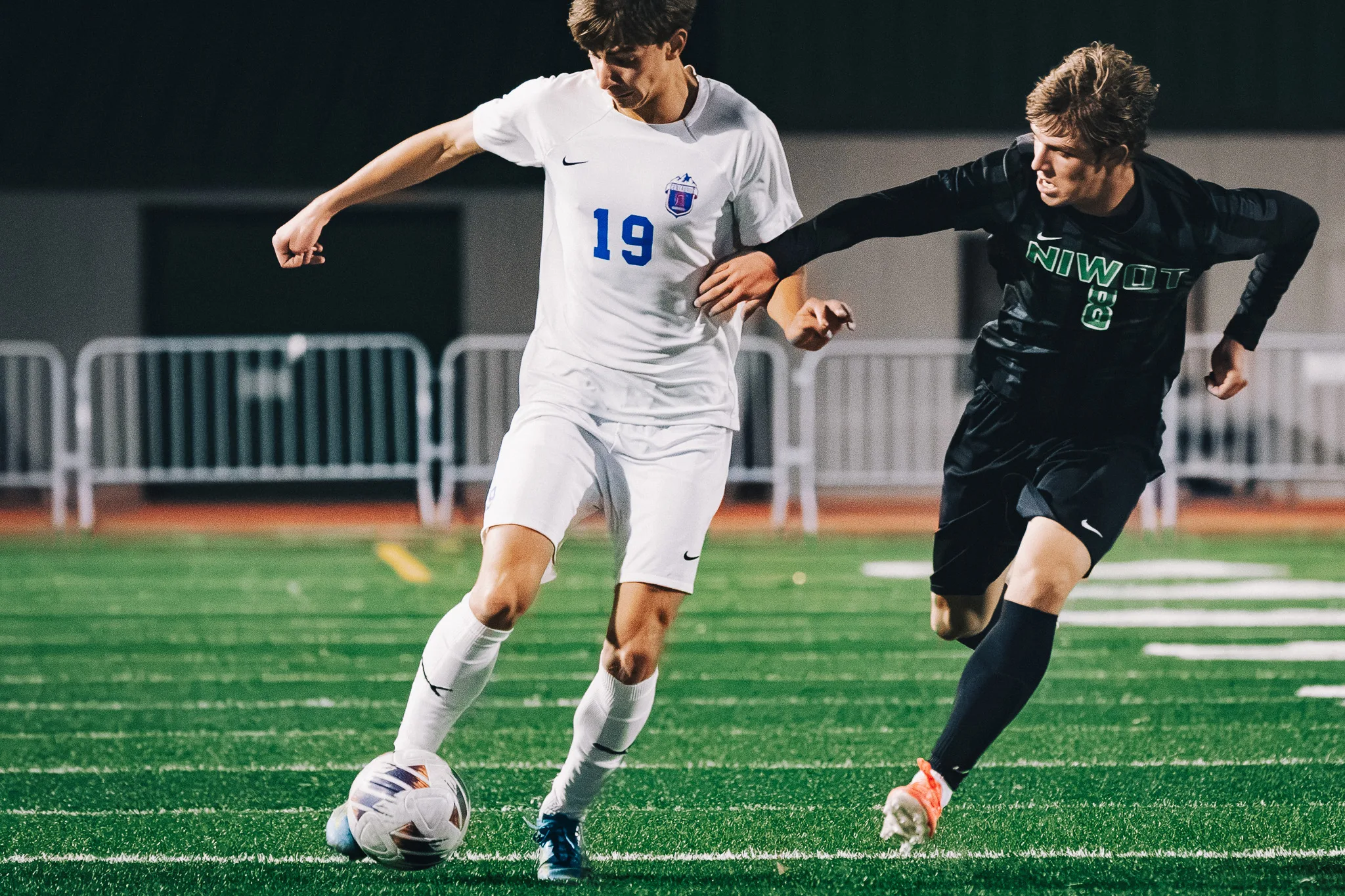 Centaurus number 19 shields the ball as Niwot number 8 reaches across him