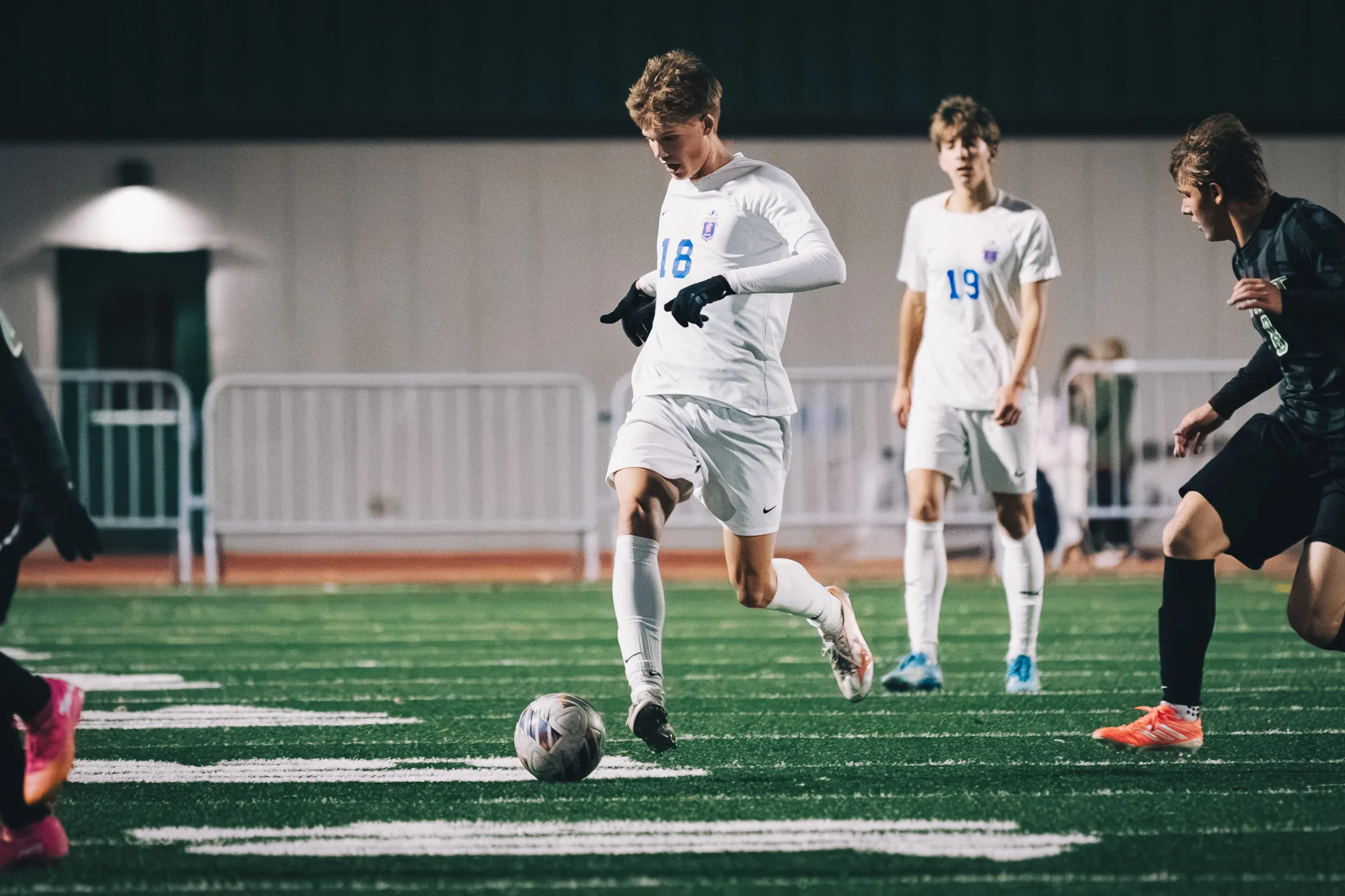 Centaurus number 18 brings the ball forward as teammate number 19 trails behind and a Niwot player comes in from the right