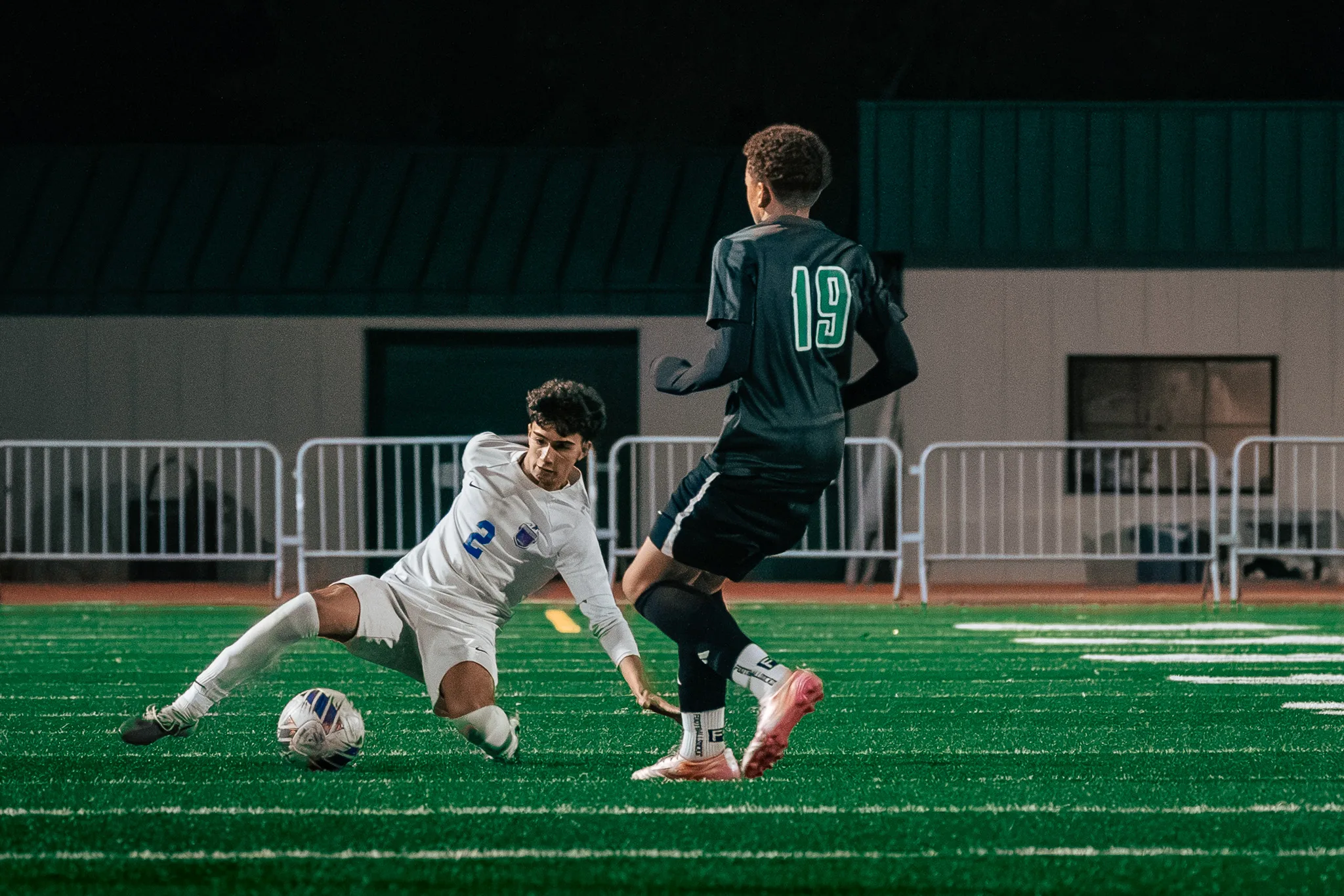 Centaurus number 2 slides on the turf toward the ball as Niwot number 19 runs past