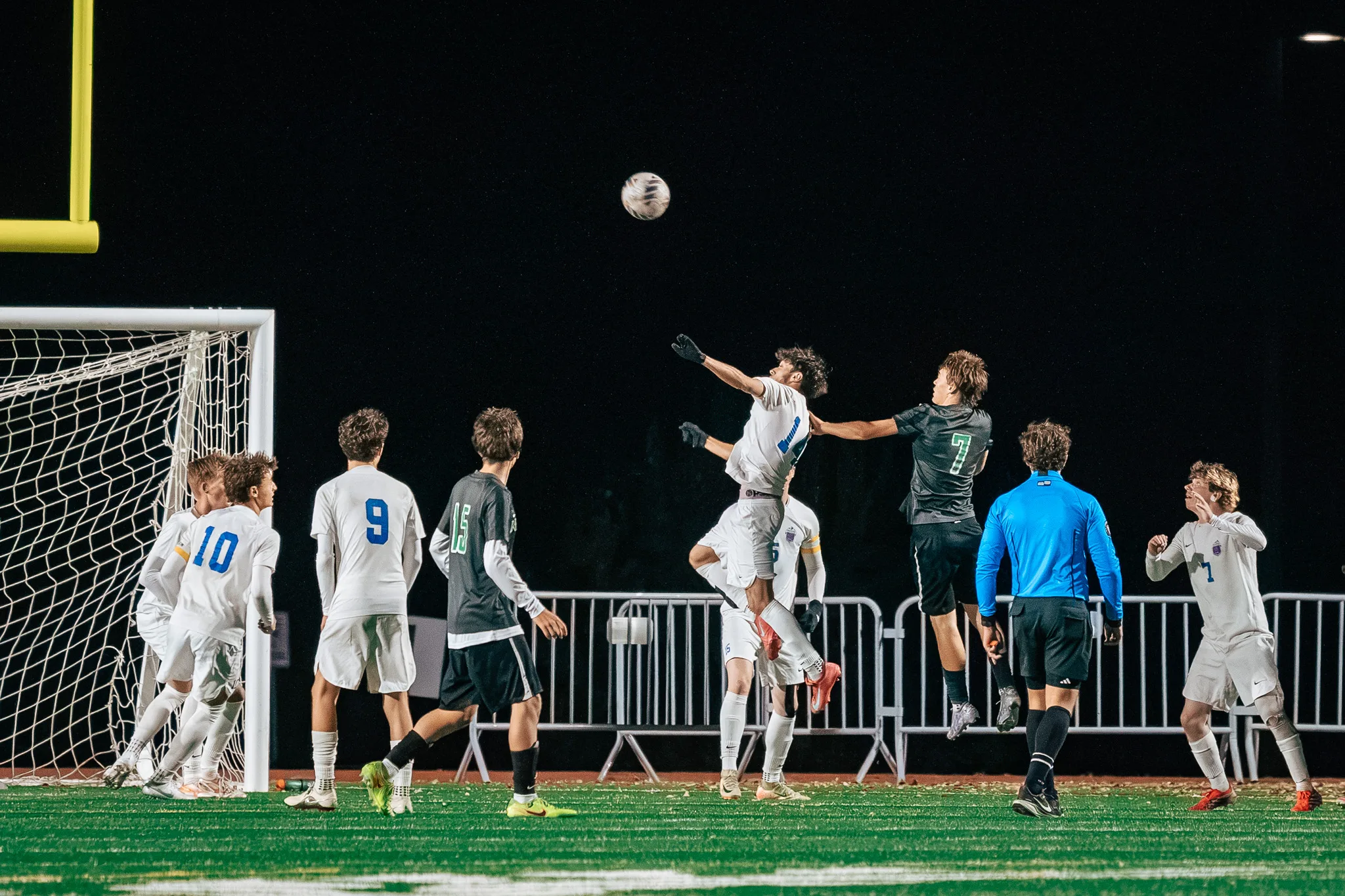 In front of the goal, a Centaurus player and Niwot number 7 leap for a high ball while Centaurus numbers 10 and 9, Niwot number 15 and a referee in blue look up
