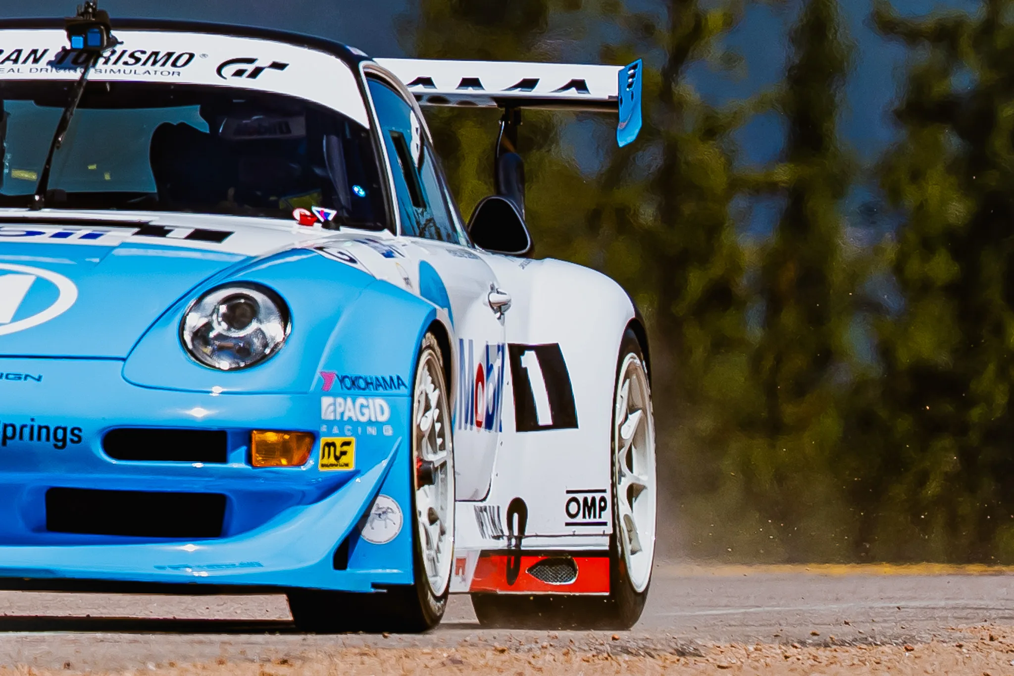 Jeff Zwart's light blue #11 1997 Porsche 993 in Mobil 1 livery kicking up dust at the 2025 Pikes Peak International Hill Climb, Pikes Peak Open